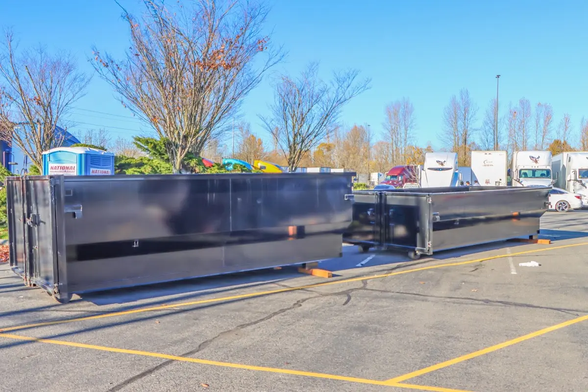 Professional dumpster rental service with roll-off container on residential driveway in Upper